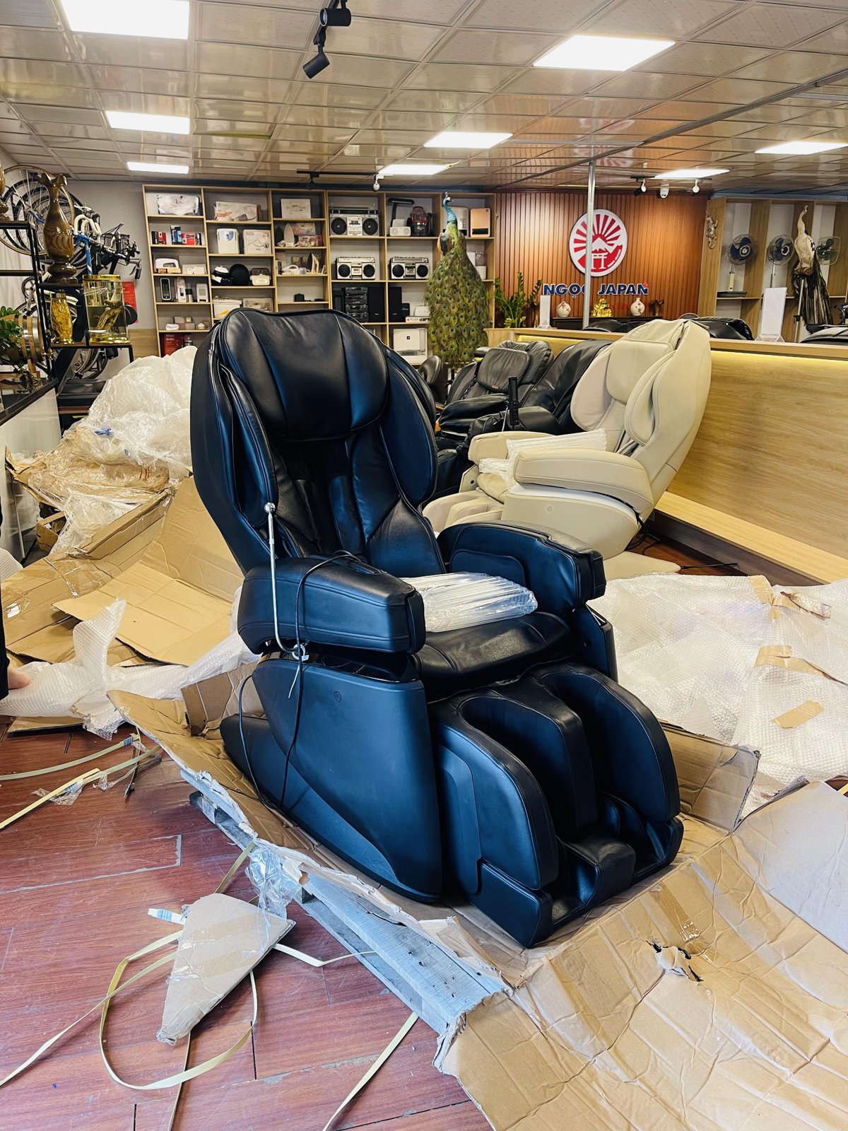 Khách hàng ngồi thử ghế massage nội địa Nhật tại showroom NgocJapan Hưng Yên, so sánh cảm giác con lăn với các dòng ghế thị trường như D'san