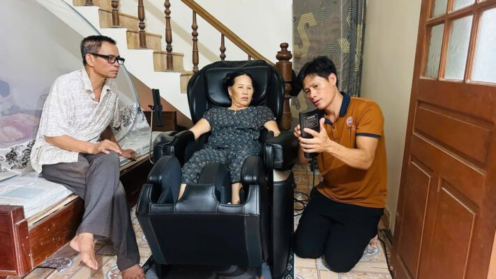 Khách hàng trải nghiệm ghế massage nội địa Nhật tại nhà cùng nhân viên Ngọc Japan, kiểm tra khả năng vận hành thực tế.